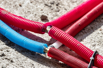 Water pipes corrugated in red and blue. Plumbing system in the floor. Pipe laying on the floor of...
