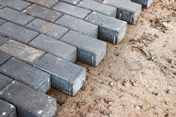Pavement repairs and paving slabs laying on the prepared surface, with tile cubes in the...