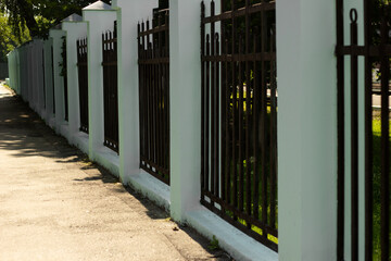 Photo of a sidewalk and a metal fence