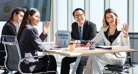 Fototapeta na wymiar Millennial Asian successful professional male businessmen and female businesswomen audiences in formal suit sitting together waving hands greeting newcomer in company conference office meeting room