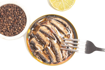 canned smoked sprats in oil with spices and lemon top view