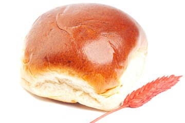 fresh baked wheat buns with wheat ears isolated on white