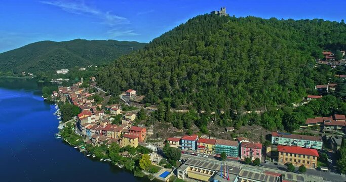 Aerial view of the lakeside city of PIediluco with the fortress that dominates the area. Forward movement of the drone. Piediluco, province of Terni, Umbria, Italy, Europe