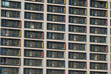 Fototapeta na wymiar Apartment building facade with many windows as background