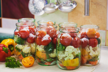The process of preserving cucumbers and tomatoes for the winter.