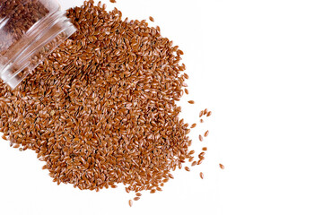 Flax seeds spill out of the jar. Isolate on a white background. View from above. Place for text