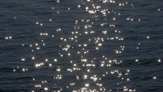 Slow motion of sun reflecting on sparkling blue sea. Sunrise at the sea or ocean