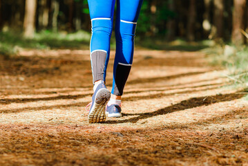 Fototapeta na wymiar Female runner jogging outdoors through a summer forest trail.Close up.Copy space.