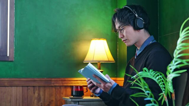 暗い部屋で本を読む男性