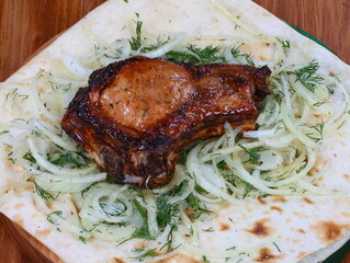 Shish kebab on ribs with onions on pita bread