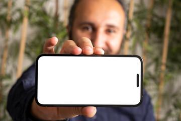 Holding horizontal smartphone, portrait of caucasian man holding horizontal smartphone. Modern...