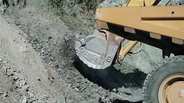 Excavator digger digging limestone in open pit mine. Development opencast for mining minerals. Mining excavator with electric shovel, slow motion
