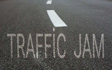empty asphalt road and white road line with "traffic jam" written on the road