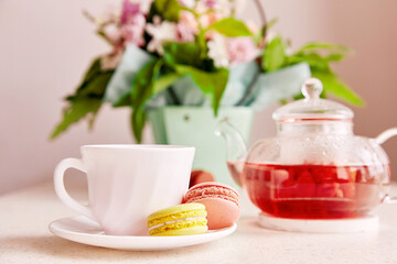 Cup of tea with macaroons. Herbal natural raspberry tea time at aesthetic home. Cozy home, self care, wellness lifestyle