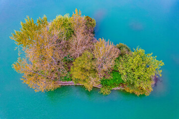 Bezludna wyspa na jeziorze, jesienią z lotu ptaka