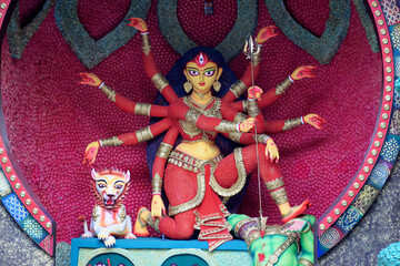 Idol of Goddess Devi Durga at a decorated puja pandal in Kolkata, West Bengal, India. Durga Puja is a famous and major religious festival of Hinduism that is celebrated throughout the world. - obrazy, fototapety, plakaty