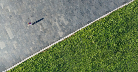 Drone shot of a young woman enjoying a beautiful sunny day on roller skates