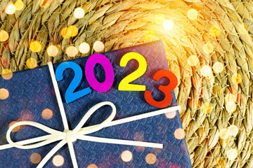 happy new year 2023 numbers above gift box on halfah with bokeh light