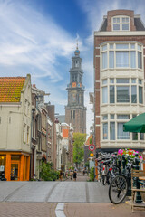 Fototapeta na wymiar Narrow Street and the Dome of the Ancient Cathedral in Amsterdam