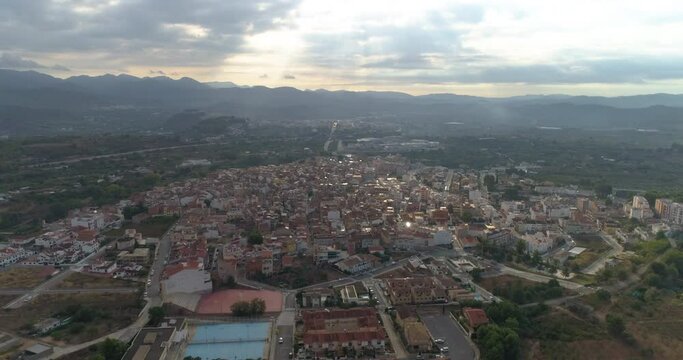 Vuelo sobre pueblo de Valencia con campanario y nublado