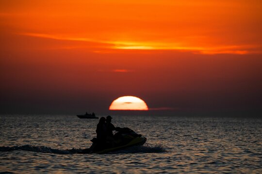 Beautiful shot of a pair on a jet ski in the sea in the sunset