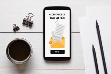 Acceptance of job offer concept on smartphone screen with office objects on white wooden table. Flat lay