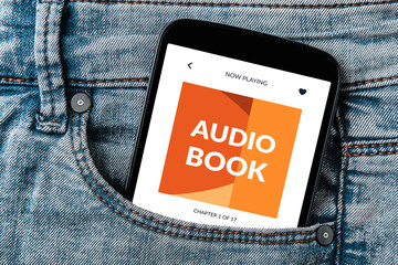 Audio book app concept on smartphone screen in jeans pocket.