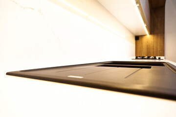 Modern brown wood oak kitchen cabinet equipment and granite black sink in a home