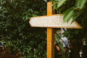 Wooden sign reading "Ceremony" in italian during wedding day celebrations. Detail of wedding decorations