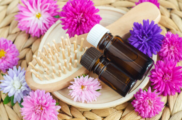 Wooden hair brush and bottles with essential oil. Aromatherapy, natural beauty treatment, hair care.
