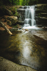 Fototapeta na wymiar small waterfall in the mountain forest 