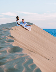 A couple walking at the beach of Maspalomas Gran Canaria Spain, men and woman at the sand dunes...