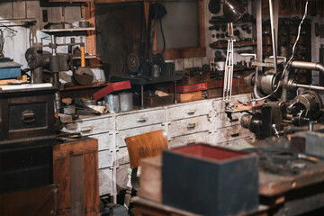 Vintage tools, equipment and antique objects in authentic historical carpentry shop. Woodwork, blacksmith and restoration concept.