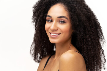 Portrait view of the beautiful multiracial woman with naked shoulders smiling while standing at the isolated white background. Stock photo