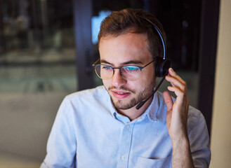 Call center, customer service and telemarketing with a man working in support with a headset in his office. Sales, consulting and contact us with a male consultant at work in crm communication