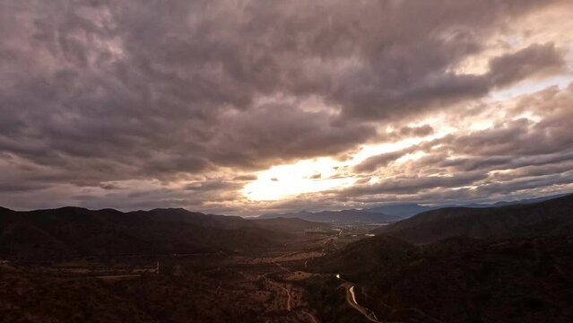 Timelapse clouds and sunset. Dusk, falls to night between mountains