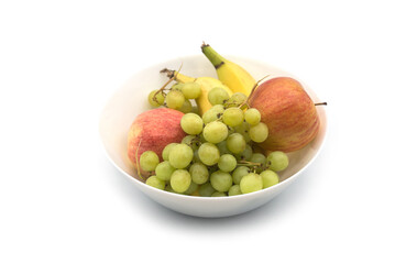 Closeup of organic fruits in a white bowl on white background