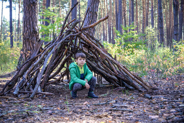 In the spring or autumn in the pine forest the boy plays he buil