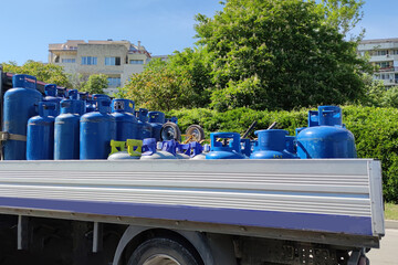 truck carries blue gas cylinders in an open body