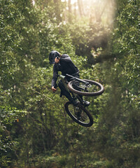 Cycling, bicycle jump and sports man travel in Japan nature forest for adventure and extreme sport...