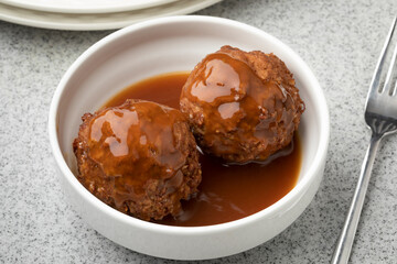 Dish with traditional Dutch baked meatball and sauce on the table close up - obrazy, fototapety, plakaty