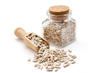 Nasiona słonecznika w drewnianej szpatułce i małym słoiczku na białym tle