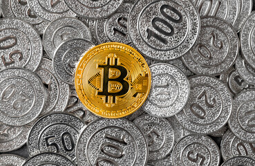 Bitcoin coins in a pile of regular money