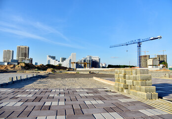 Paving bricks at construction site. Laying paving slabs and borders in town pedestrian zone....