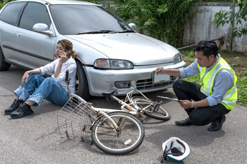 Car Insurance agent man checking damages from bicycle accident for claimming with woman driver sitting near car 