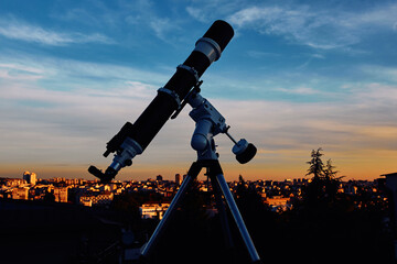 Big astronomical telescope under a twilight sky ready for stargazing.