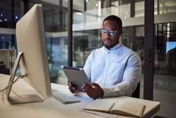 Black businessman, tablet planning and desktop at night in startup for online ideas, strategy and connect apps on 5g technology in Nigeria. Employee working in dark modern office for internet project