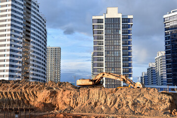 Excavator dig ground at construction site. Dig foundation. Construction of residential buildings,...