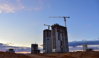 Fototapeta na wymiar Сonstruction site with tower cranes on building construction. Builder on formworks. Cranes on pouring concrete in formwork. Tower cranes on construction. Built environment. Buildings renovation..