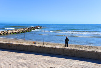 Fisherman catches fish on the coast near the sea. Catching fish in the sea from the shore. Fishing...